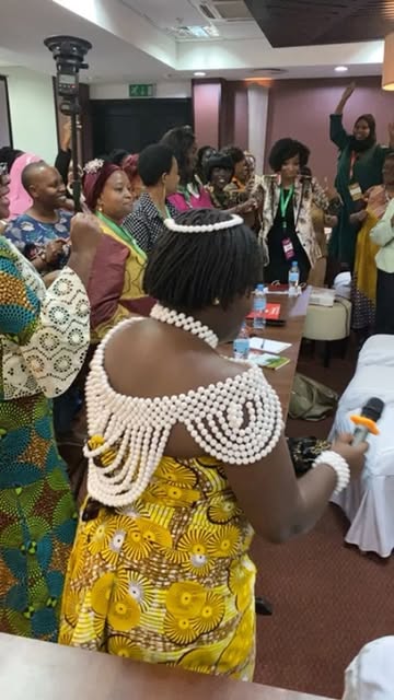 A delegate in traditional dress celebrating on the conference floor